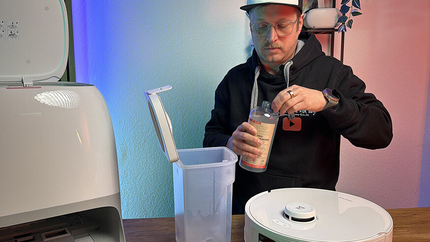 Multifunktions-Station des Roborock Qrevo Curv 2 Flow in Weiss mit abgerundeten Kanten. Die Station zeigt den getrennten Frischwasser- und Schmutzwassertank sowie den Staubbeutelbehaelter. Smart Home Fox.